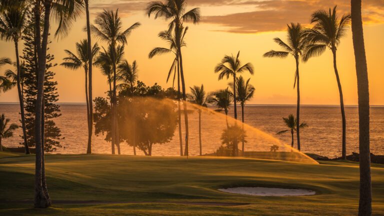 Golf course at sunset with sprinkler and nice back light
